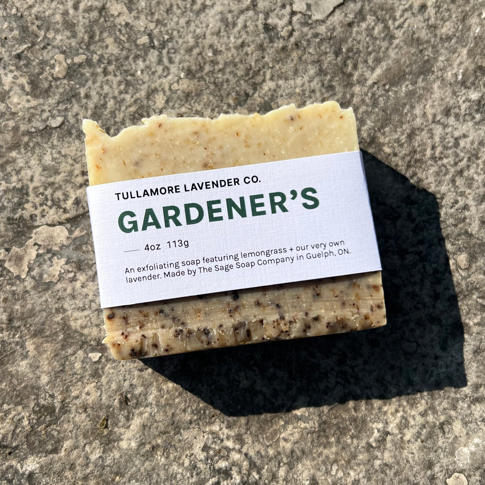 Tan soap bar with dark speckles throughout + label that reads "GARDENER'S"