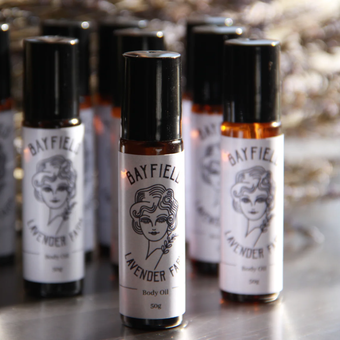 Several small roll-on bottles standing together with white Bayfield Lavender labels on them