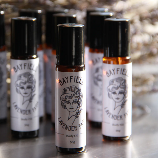 Several small roll-on bottles standing together with white Bayfield Lavender labels on them