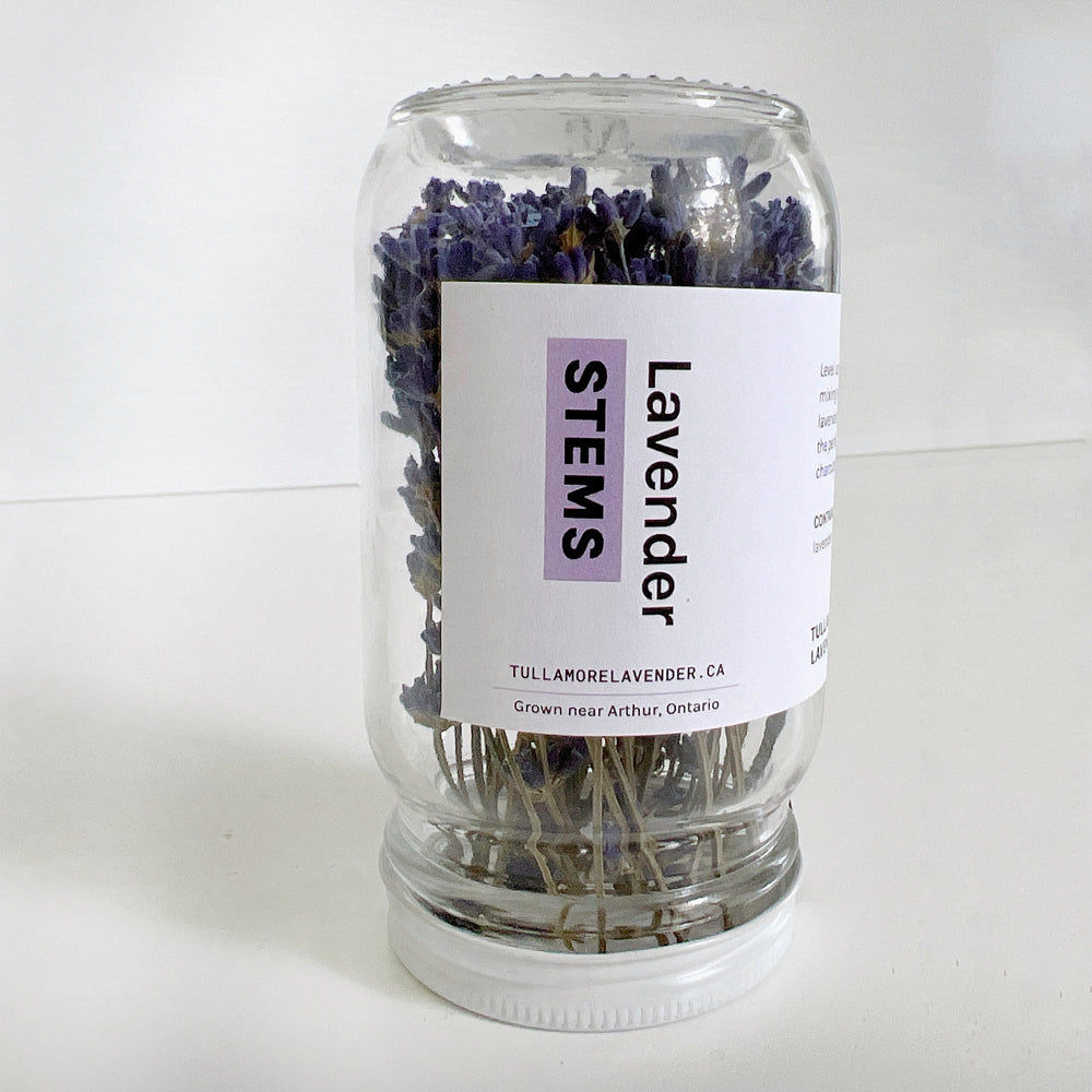 Small glass jar with white label on it that says "Lavender STEMS"