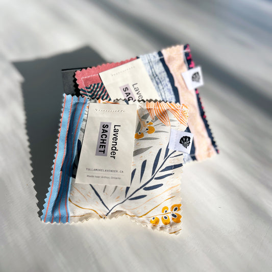 Two large farbic sachets in colourful fabrics lie on a white table, sunshine hitting them