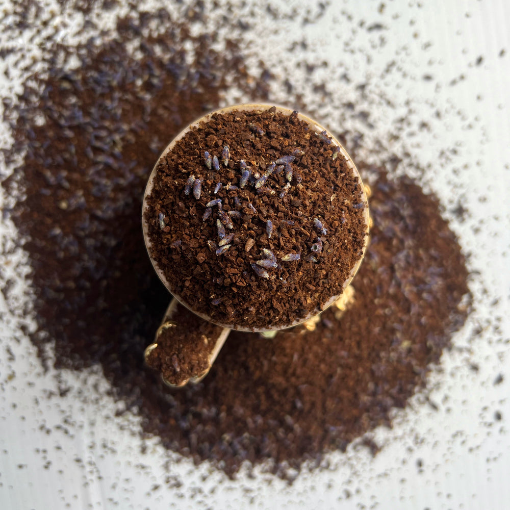 Coffee cup overfilled with coffee grounds and lavender buds