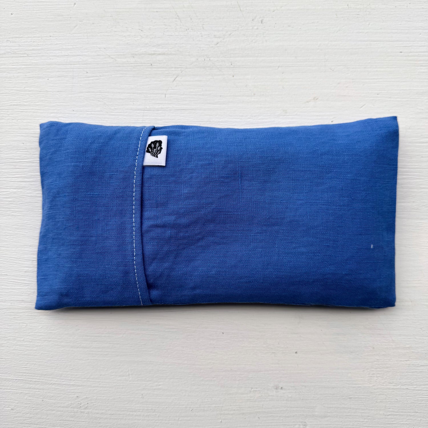 Blue eye pillow with white TLC tag