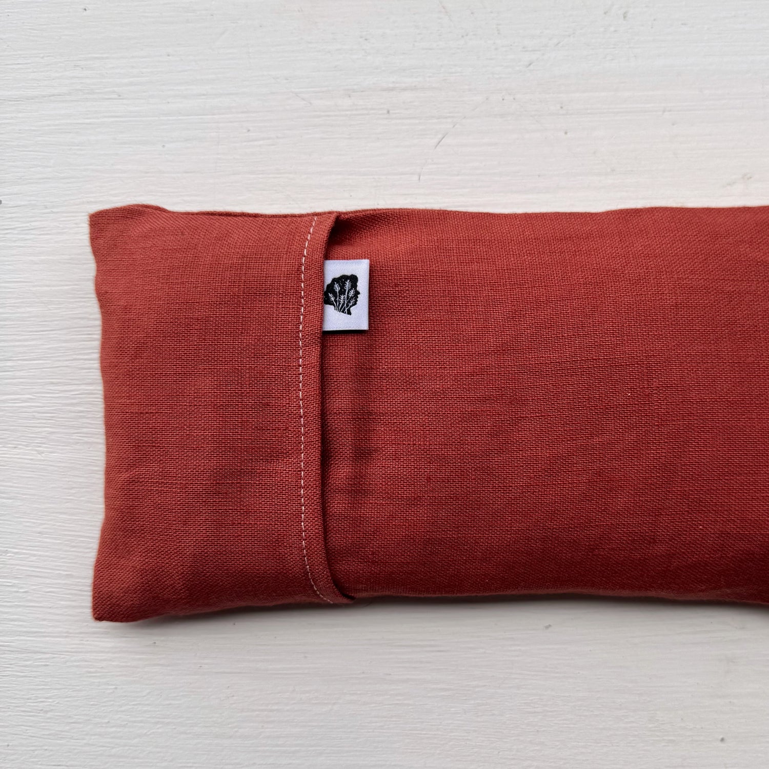 Terra cotta eye pillow with white TLC tag