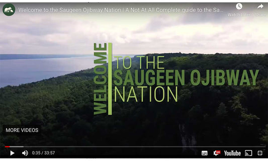 Video screenshot from YouTube showing a forested landscape beside vast water with the following words overtop "Welcome to the Saugeen Ojibway Nation"