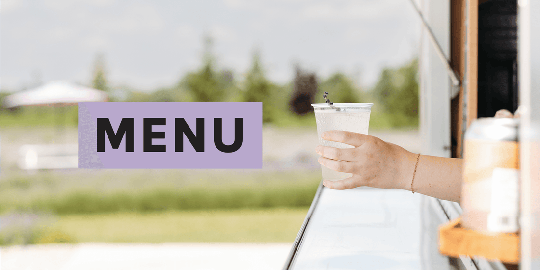 Menu with white woman's hand holding out a drink with a lavender stem in it