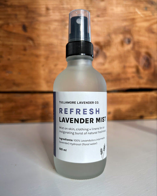 White frosted glass bottle with label that says "Refresh Lavender Mist"