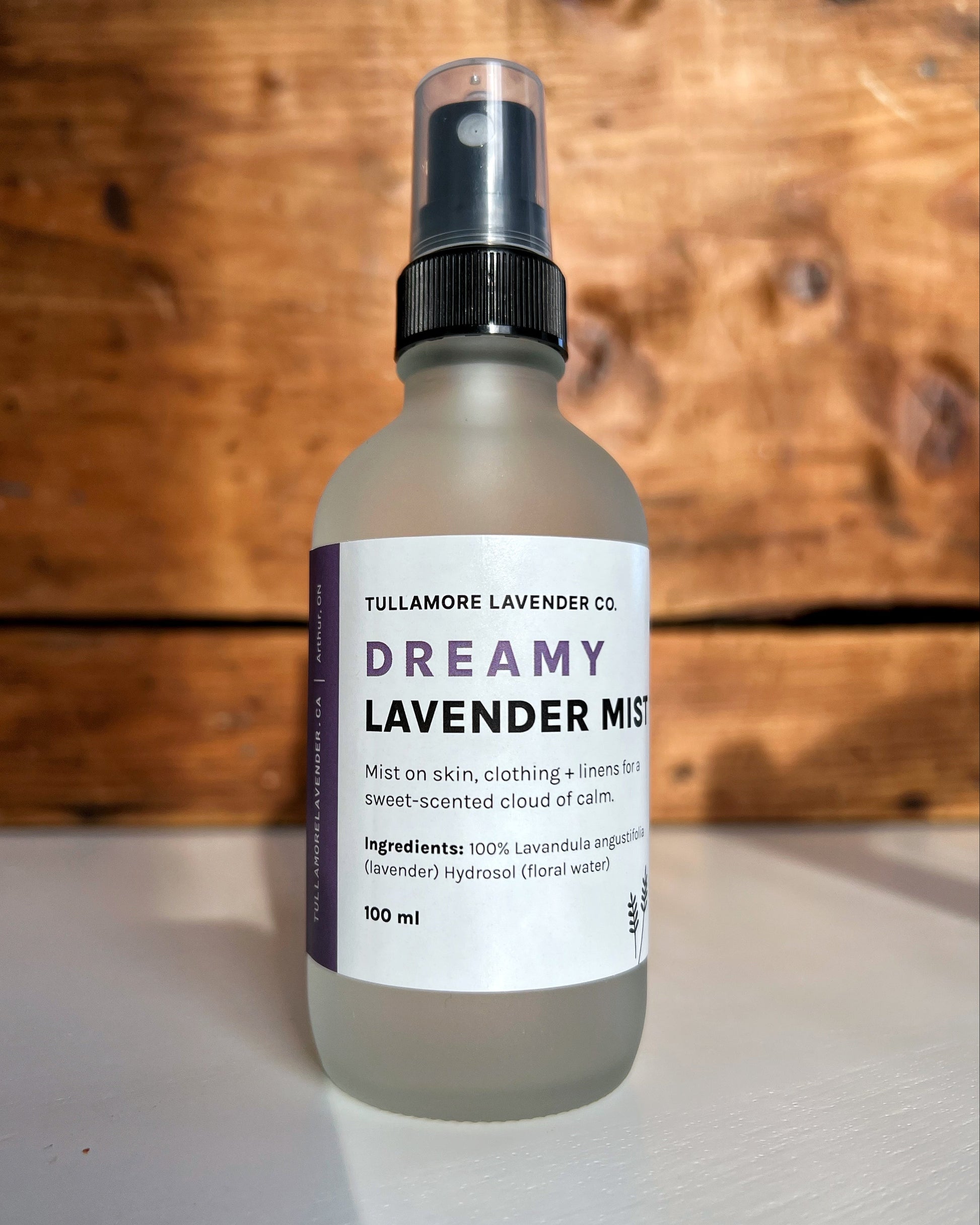 Frosted glass spray bottle with white label that says "Dreamy Lavender Mist"