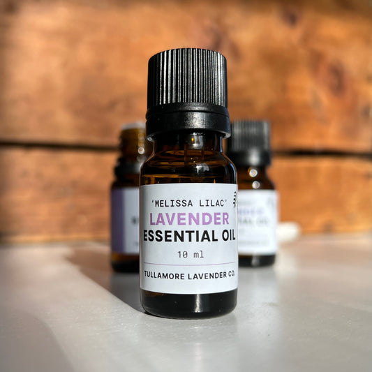 Small amber bottle with black cap and label that says Melissa Lilac Lavender Essential Oil