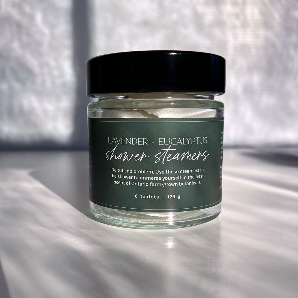 Jar of lavender and eucalyptus shower steamers on a textured surface