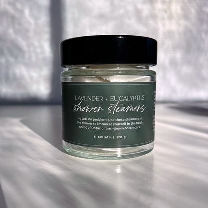 Jar of lavender and eucalyptus shower steamers on a textured surface