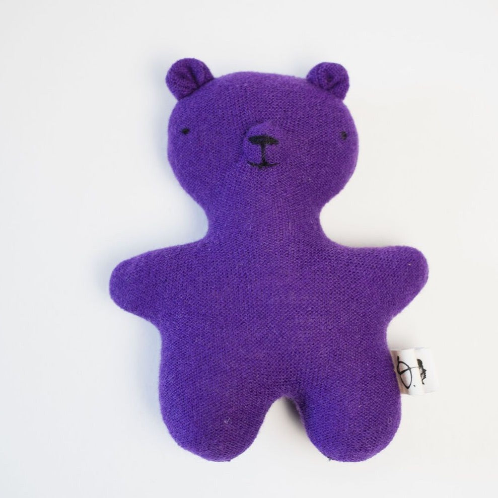 Bright purple teddy bear on white background 