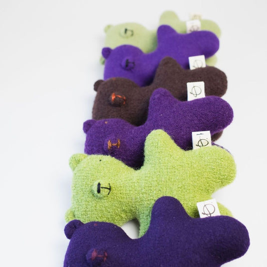Green, purple and brown bears laying on white
