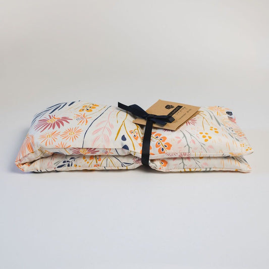 Wrap in light floral fabric folded with ribbon and brown paper tag